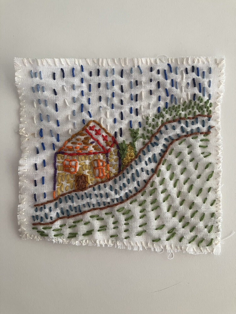 Broderie représentant une maison et un chemin