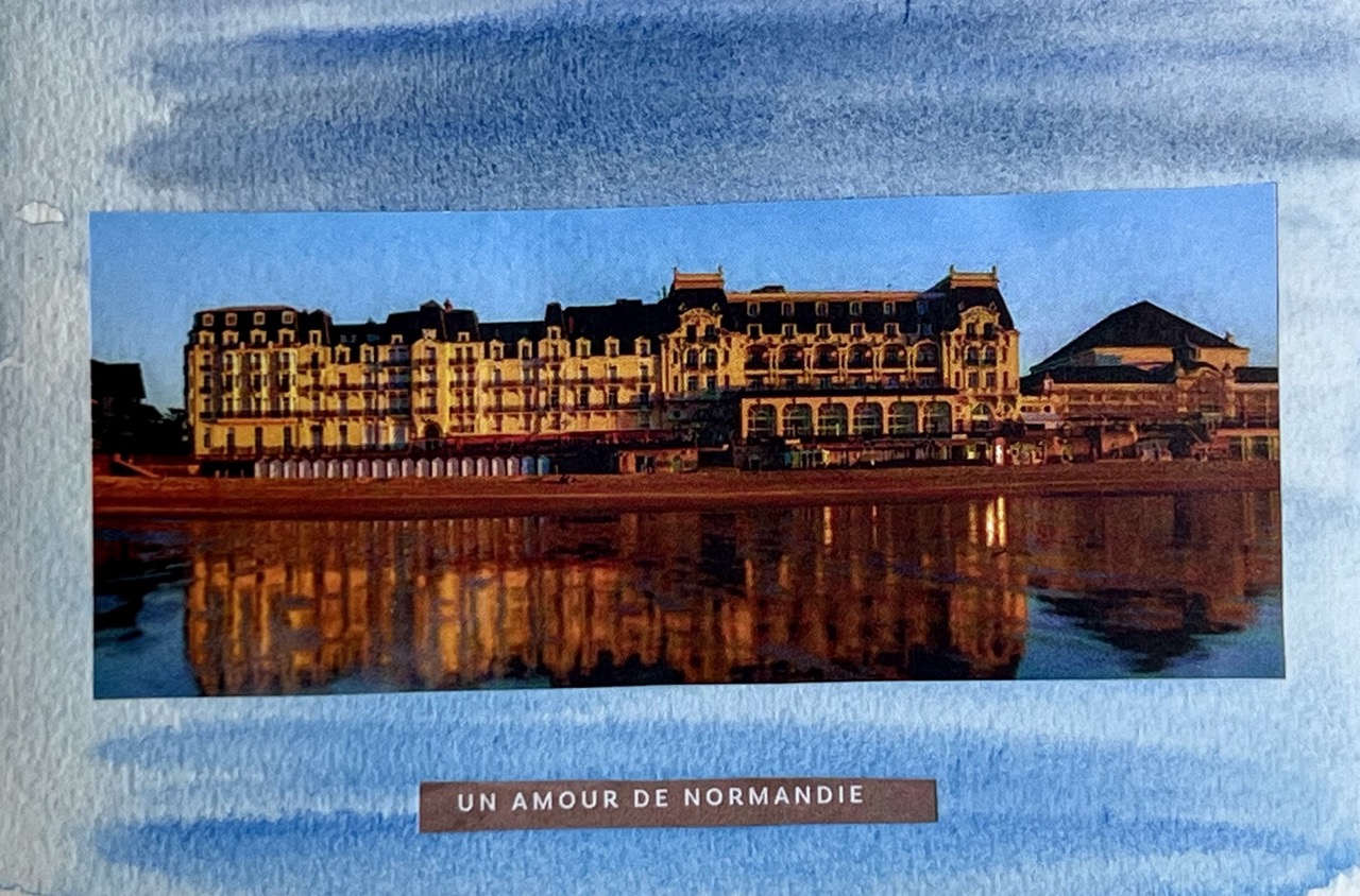 Carte postale collage du Grand Hôtel de Cabourg reflété sur la plage au crépuscule, légende « Un amour de Normandie »